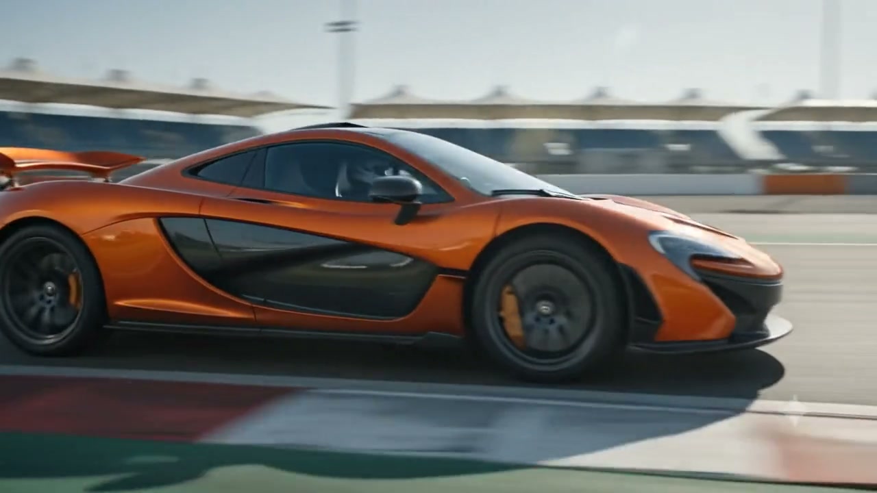 Orange McLaren P1 at speed on a race track straight