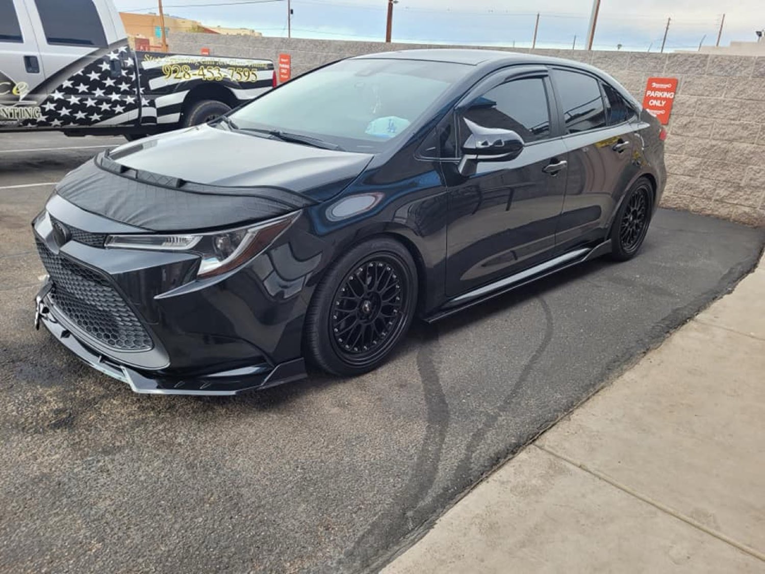 Customer's customized black Toyota Corolla outside the shop