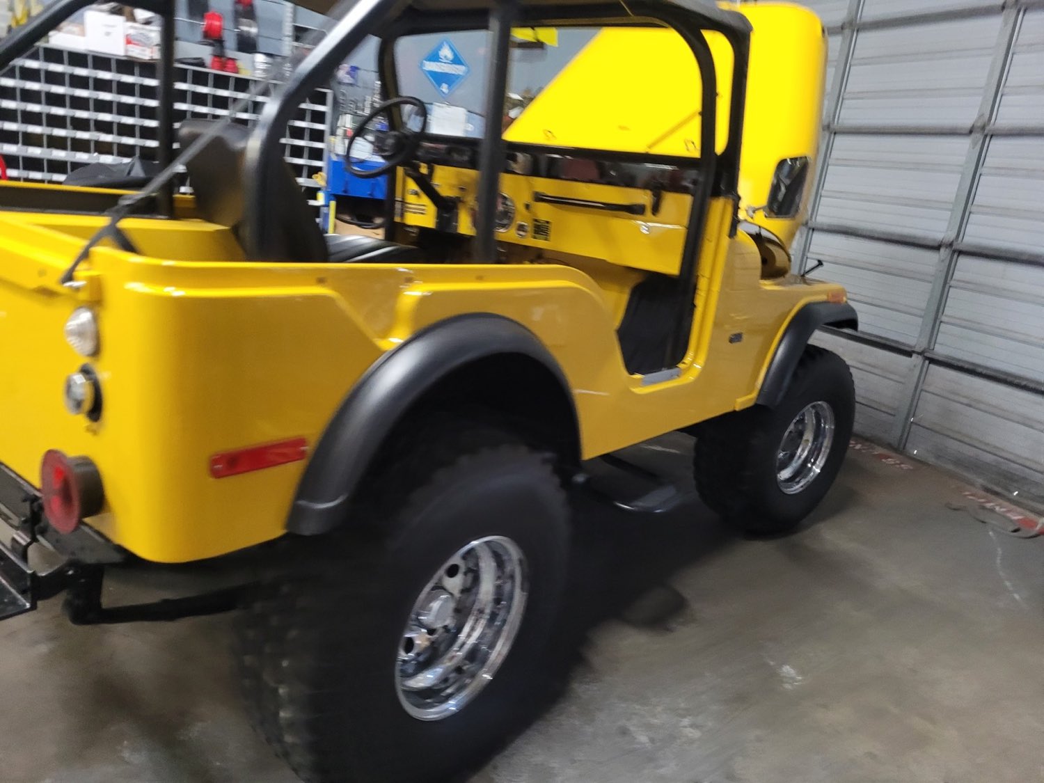 Restored yellow Jeep CJ off-roader inside the Autoworks shop