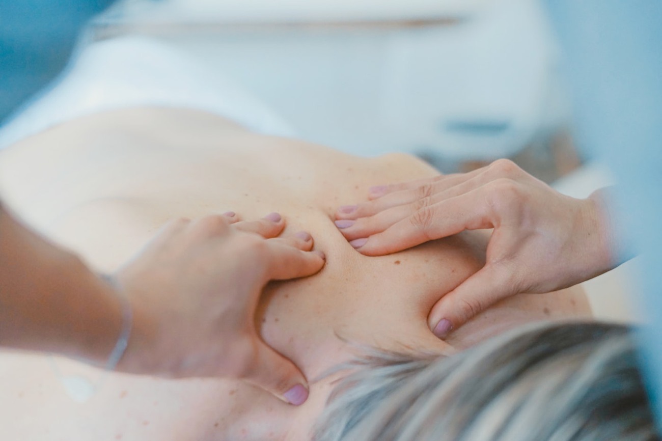 A calm, flowing shoulder and upper-back massage in a bright room