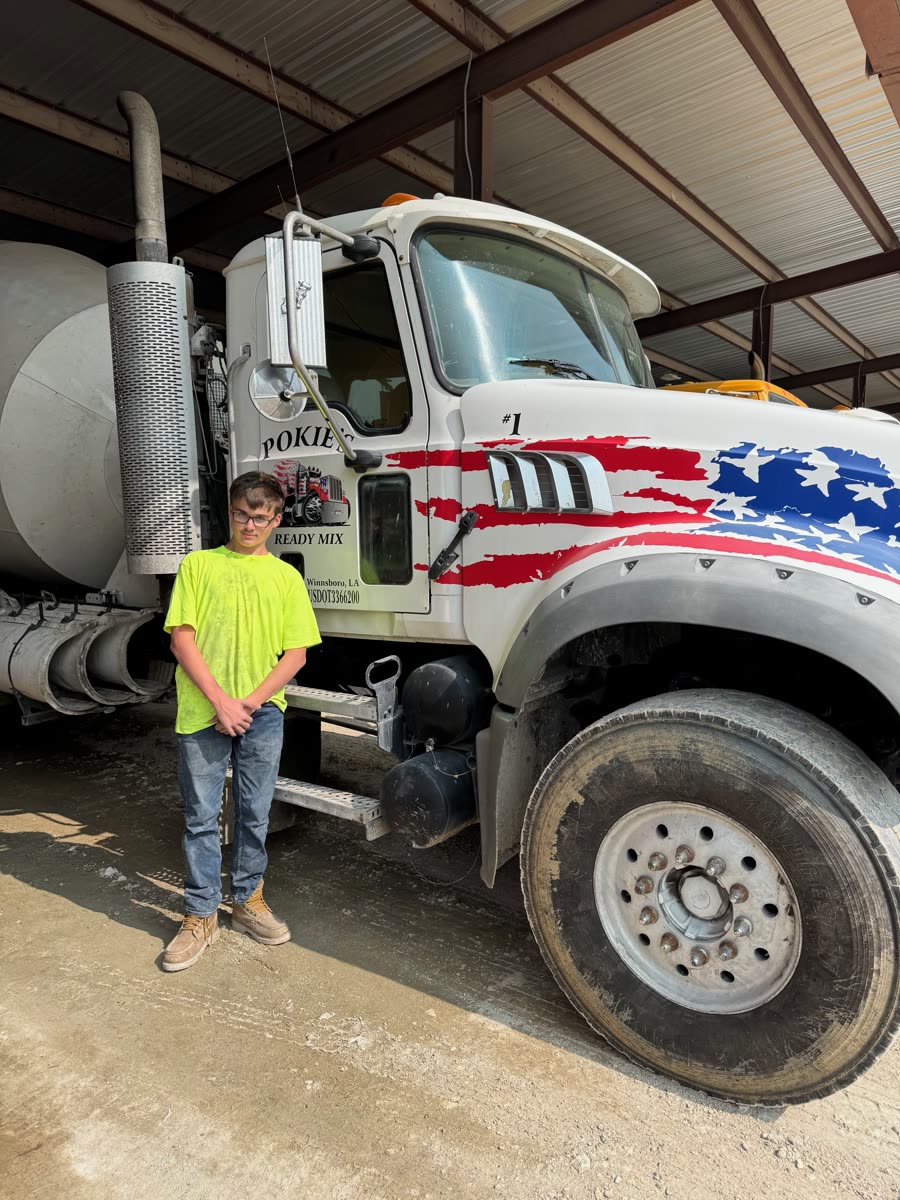 Pokie's crew member beside mixer truck number 1 with its American flag wrap