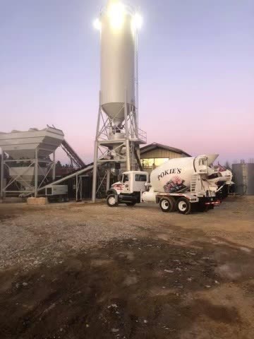 Pokie's batch plant silo lit up before sunrise