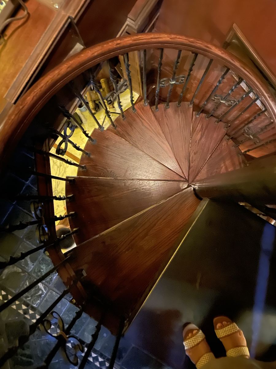 Sunlit wooden spiral staircase in a boutique hotel