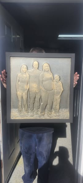 Hand-finished relief portrait panel of a family, framed in black