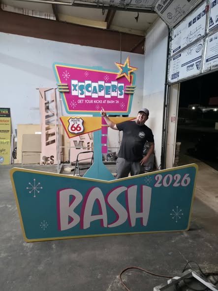 The owner in the shop with the finished retro Bash 2026 sign set